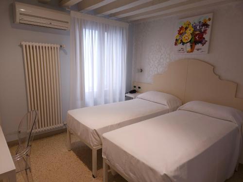 Ένα ή περισσότερα κρεβάτια σε δωμάτιο στο Hotel Adriatico