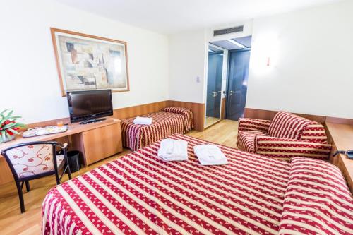 a hotel room with a bed and two chairs at Melas Hotel in Merate