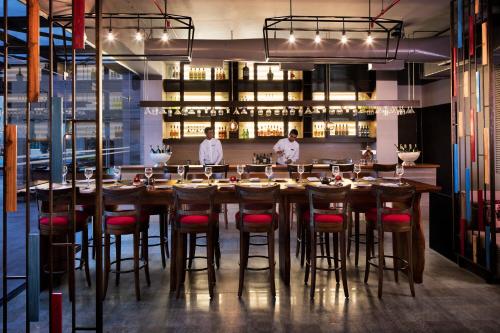 two men standing at a long table in a restaurant at Courtyard by Marriott Bengaluru Outer Ring Road in Bengaluru