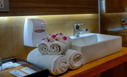 a bathroom with a sink and towels on a counter at TreeHouse Neptune in Panaji