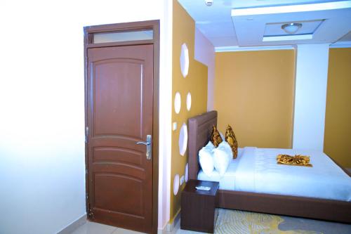 a bedroom with a bed and a door to a room at IZA Serene city centre apartments in Kigali