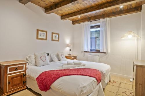 a bedroom with a large white bed and a window at Luderna - Apto con terraza Cap de la Vila in Vielha