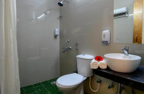 a bathroom with a toilet and a sink at TreeHouse Neptune Inn in Panaji