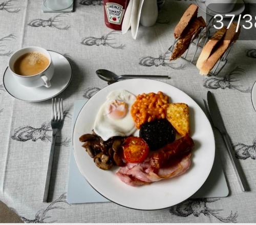 a plate of breakfast food and a cup of coffee at The Old Manse B&B in Thurso