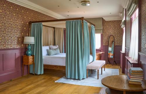 a bedroom with a bed and curtains in a room at The Mitre, Hampton Court in Kingston upon Thames