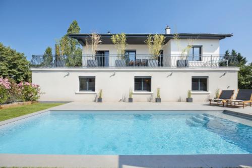 une villa avec piscine devant une maison dans l'établissement Villa avec piscine a 25 min de lyon, à Saint-Genis-les-Ollières
