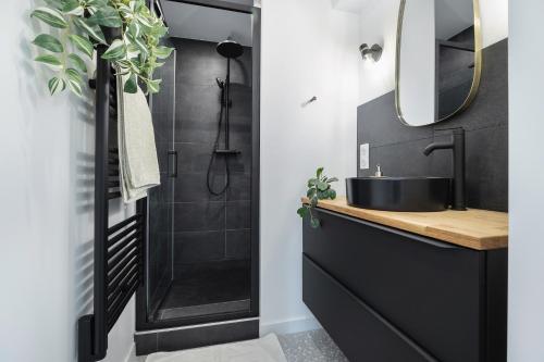 La salle de bains est pourvue d'un lavabo noir et d'une douche. dans l'établissement Villa avec piscine a 25 min de lyon, à Saint-Genis-les-Ollières