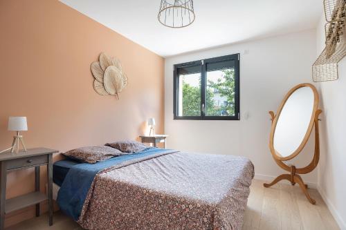 une chambre avec un lit, un miroir et une table dans l'établissement Villa avec piscine a 25 min de lyon, à Saint-Genis-les-Ollières