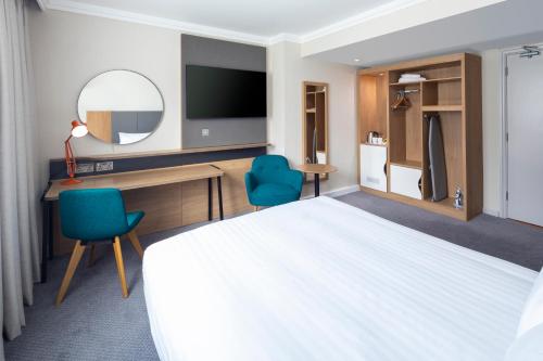 a hotel room with a bed and a desk and a tv at Holiday Inn London - Gatwick Airport, an IHG Hotel in Horley