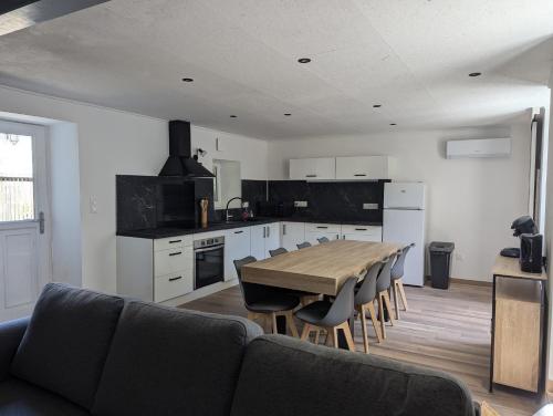 une cuisine avec une table et des chaises dans une pièce dans l'établissement Maison de village au centre de Vallon-Pont-d'Arc, à Vallon-Pont-dʼArc