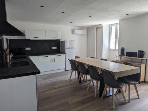 une cuisine et une salle à manger avec une table et des chaises dans l'établissement Maison de village au centre de Vallon-Pont-d'Arc, à Vallon-Pont-dʼArc