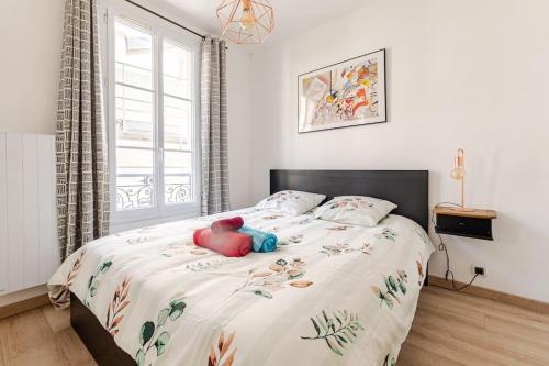 une chambre avec un lit avec un ours en peluche dessus dans l'établissement F2 au calme au cœur de Paris 13, à Paris