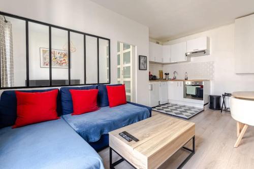 - un salon avec un canapé bleu et des oreillers rouges dans l'établissement F2 au calme au cœur de Paris 13, à Paris