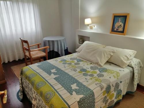 a bedroom with a bed and a chair at O Piso dos Avós in A Guarda