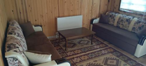 a living room with a couch and a table at Yavuzyılmaz Tesisleri in Macka