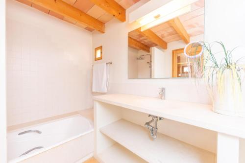 a white bathroom with a sink and a mirror at Ses Fonolleres in Cala Bona