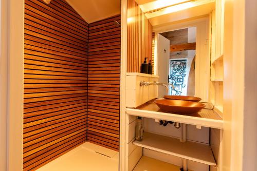a bathroom with a sink and a wooden wall at La Trêve - Mas 12 personnes rénové avec Piscine in Saint-Julien-du-Serre