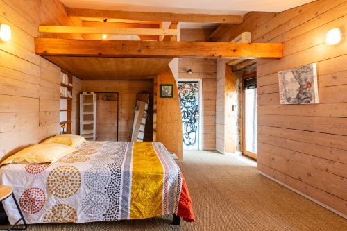 a bedroom with a bed in a wooden cabin at La Trêve - Mas 12 personnes rénové avec Piscine in Saint-Julien-du-Serre