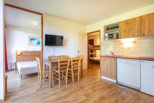 une cuisine et une salle à manger avec une table et des chaises dans l'établissement Le Chamroussien - Appt 6p, au pied des pistes, à Chamrousse