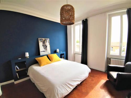 - une chambre avec un grand lit blanc et des oreillers jaunes dans l'établissement Lumineux appart 4 chambres, clim et tout équipé, à Marseille