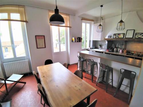 une cuisine avec une table en bois et quelques chaises dans l'établissement Lumineux appart 4 chambres, clim et tout équipé, à Marseille
