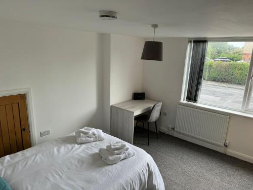 una camera da letto con un letto, una scrivania e una finestra di 2 Bed Apartment Scarisbrick Street Ormskirk - Rooms by Vici a Ormskirk