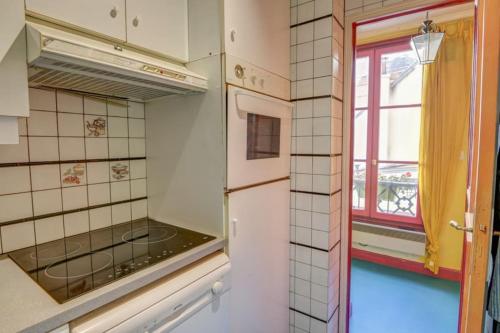 Il comprend une cuisine équipée d'un réfrigérateur et d'une fenêtre. dans l'établissement Coeur Paris authentique, à Paris