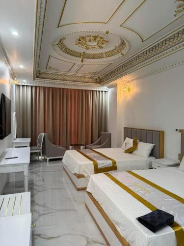 a hotel room with two beds and a television at Đông Thắm Hotel in Diện Biên Phủ