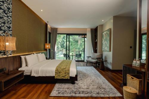a bedroom with a large bed and a balcony at Plataran Puncak Residences in Puncak