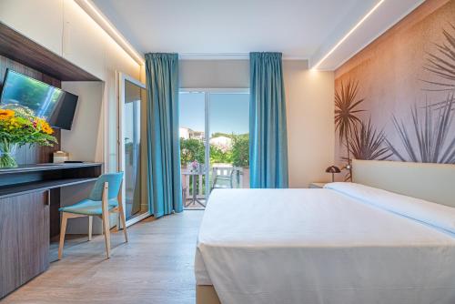 a hotel room with a bed and a balcony at Hotel Riva del Sole in Marina di Campo