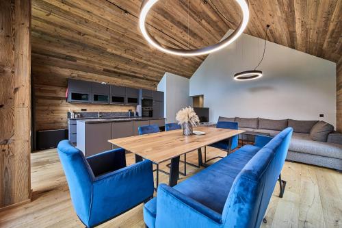 a dining room with a wooden table and blue chairs at sGmiatli – Dein Hideaway Apartment in Kappl