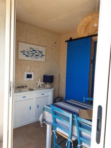 une chambre avec une table bleue et des chaises ainsi qu'une cuisine dans l'établissement 