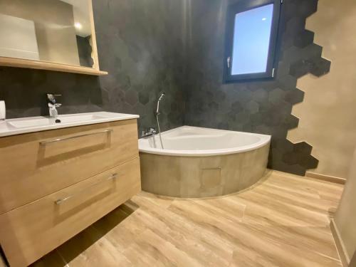 une salle de bain avec une baignoire, un lavabo et une fenêtre dans l'établissement Villa de luxe entre mer et montagne, à Villetelle