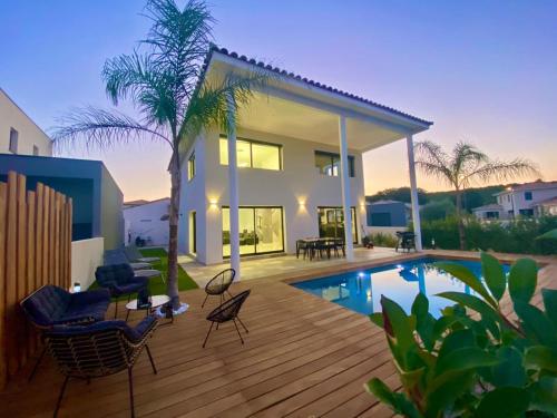 une maison avec une terrasse et une piscine dans l'établissement Villa de luxe entre mer et montagne, à Villetelle