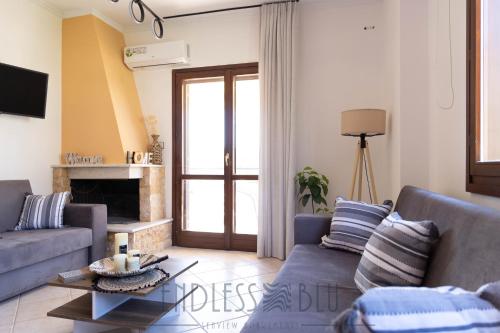 a living room with a couch and a fireplace at Endless Blu Apartments in Pyrgadikia