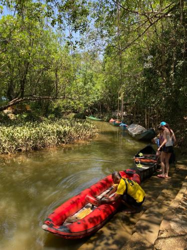 a man is in a red kayak on a river at Khlong sok camp in Ban Chieo Mon