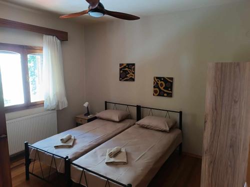 a bedroom with a large bed with a ceiling fan at Rainbow Castle Villa neos panteleimonas in Neos Panteleimonas