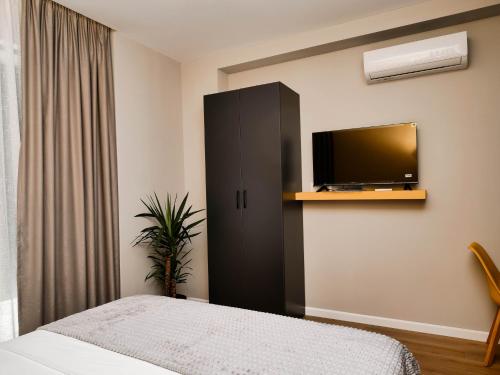 a bedroom with a bed and a tv on a wall at Bulevardi Blu 2 in Kamëz