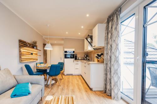 una cucina e un soggiorno con un divano e un tavolo di Ferienwohnung Auszeit a Zingst