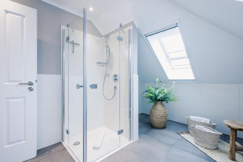 un bagno bianco con doccia e finestra di Ferienwohnung Auszeit a Zingst