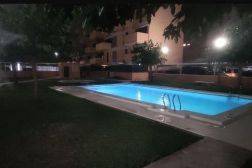 ein leeres Schwimmbecken in der Nacht in einem Hof in der Unterkunft Piso planta baja y gran patio con piscina comunitaria de alquiler temporal in Daimús