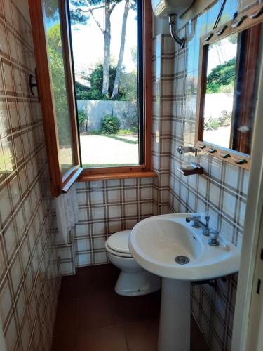 Un baño con inodoro, lavabo y ventana. en Casa Celeste, en Albinia