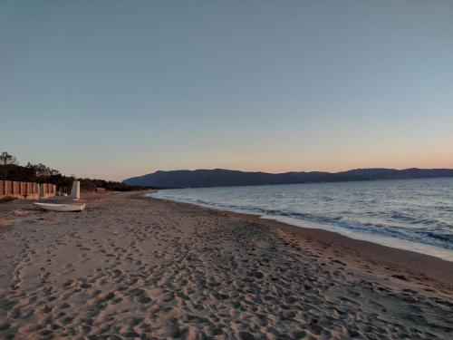 a sandy beach with a bench on the shore at Casa Celeste in Albinia