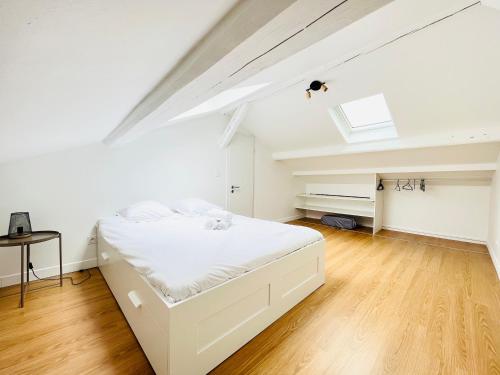 une chambre avec un lit blanc et une lucarne dans l'établissement Saint-Epvre ! Appartement T3, à Nancy