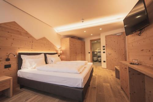 a bedroom with a bed and a flat screen tv at Monroc Hotel in Commezzadura
