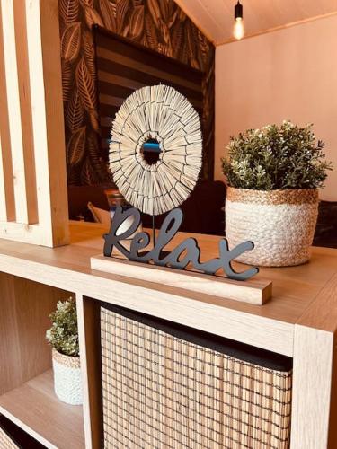 a sign on a shelf with two potted plants at Chalet des faisans in Hastière-par-delà