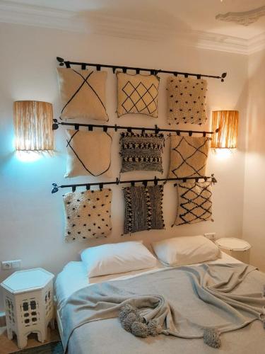 a bedroom with a bed and some pillows and lights at Vent Des Dunes in Essaouira