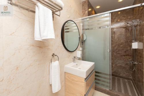 a bathroom with a sink and a shower and a mirror at Homtel Residence AUC in Cairo
