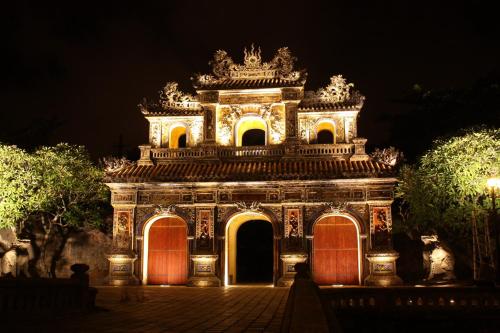 an ornate building with lights at night at SH Hotel in Hue