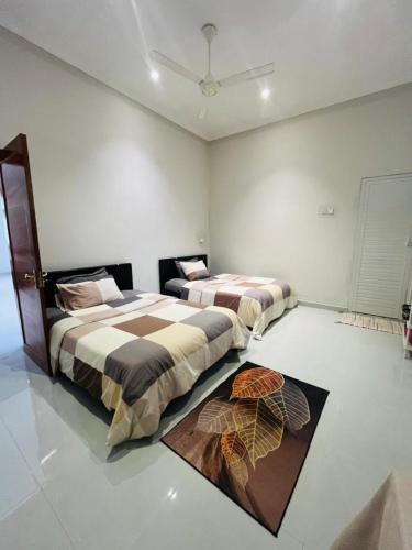 a bedroom with two beds and a rug at Blossom House Zanzibar in Kitongani